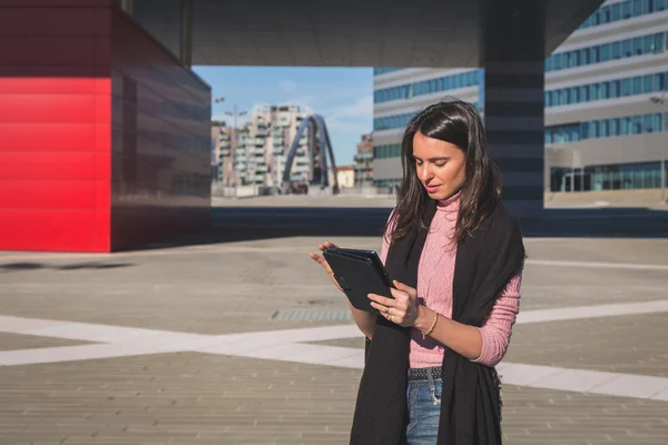 Onun tablet üzerinde çalışan güzel genç esmer — Stok fotoğraf