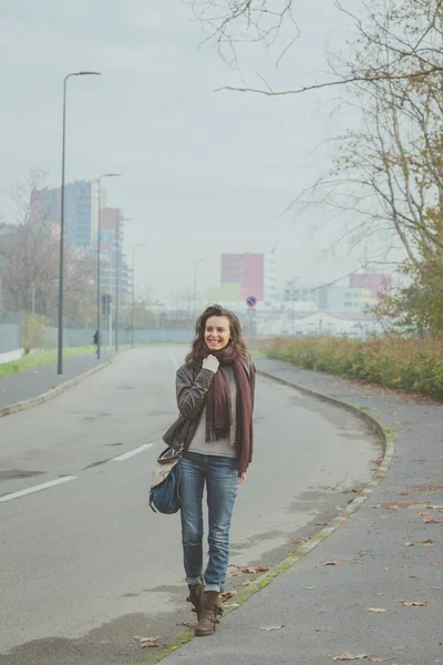 Krásná mladá brunetka pózuje v ulicích města — Stock fotografie
