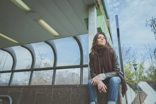 Krásná mladá brunetka pózuje v ulicích města — Stock fotografie