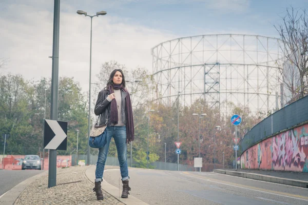 Krásná mladá brunetka pózuje v ulicích města — Stock fotografie