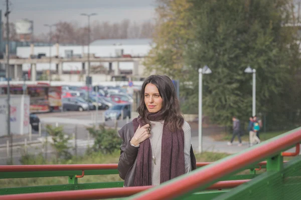 Beautiful young brunette posing on a bridge — Stock Photo, Image