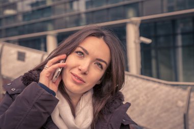 Şehir sokaklarında telefonda konuşurken genç güzel kız