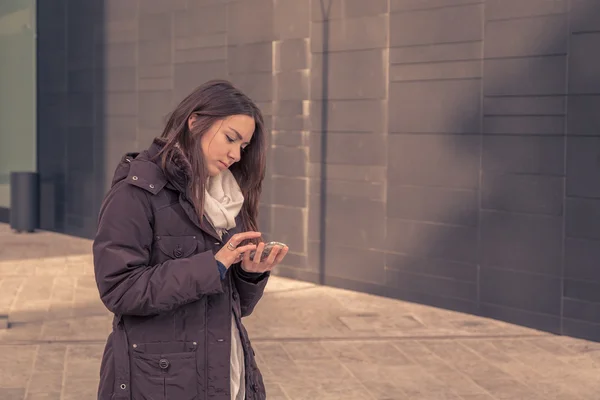 Young beautiful girl texting in the city streets — Stock Photo, Image