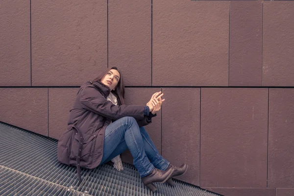 Jeune belle fille posant dans les rues de la ville — Photo