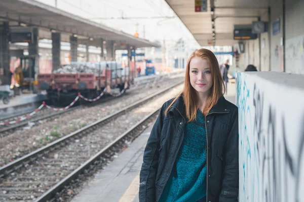 Vacker flicka poserar i en järnvägsstation — Stockfoto