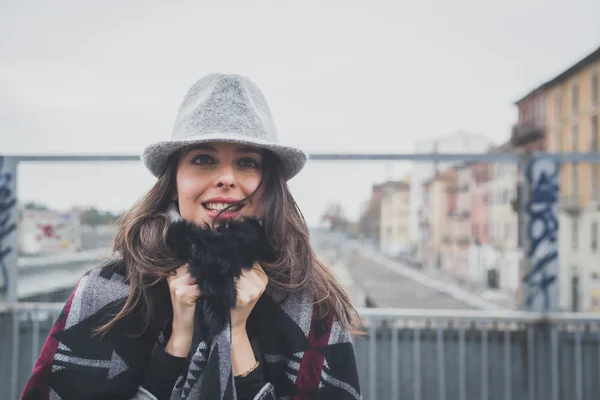 Krásná mladá brunetka pózuje v ulicích města — Stock fotografie