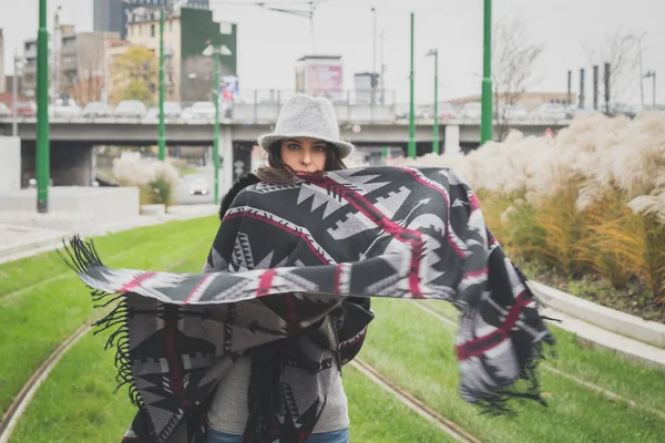 Schöne junge Brünette posiert in den Straßen der Stadt — Stockfoto