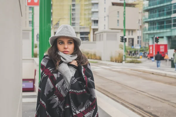 Krásná mladá brunetka pózuje v ulicích města — Stock fotografie