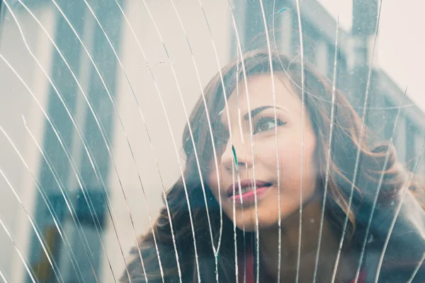 Beautiful girl posing behind a broken glass — Stock Photo, Image