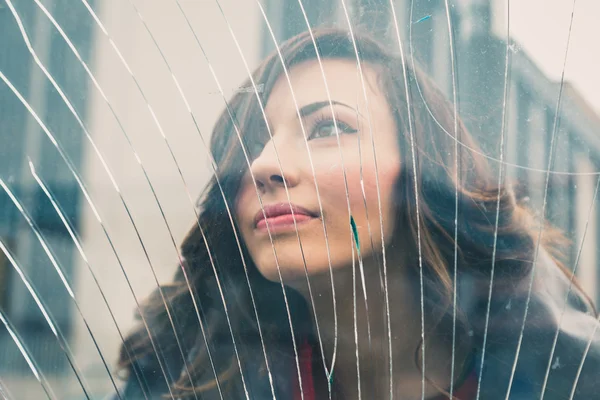 Hermosa chica posando detrás de un vidrio roto — Foto de Stock