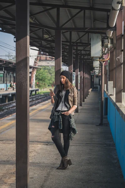 Menina bonita ouvir música em uma estação de metro — Fotografia de Stock