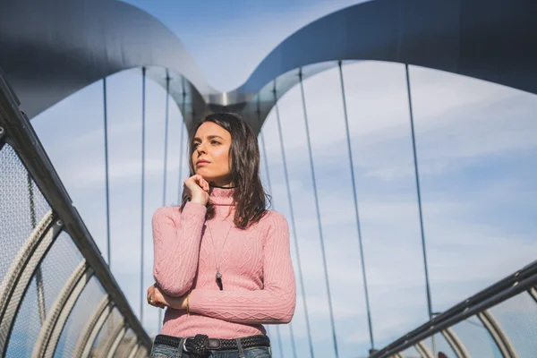 Krásná mladá brunetka pózuje na mostě — Stock fotografie