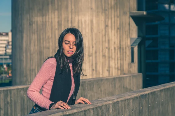 Krásná mladá brunetka pózuje v ulicích města — Stock fotografie