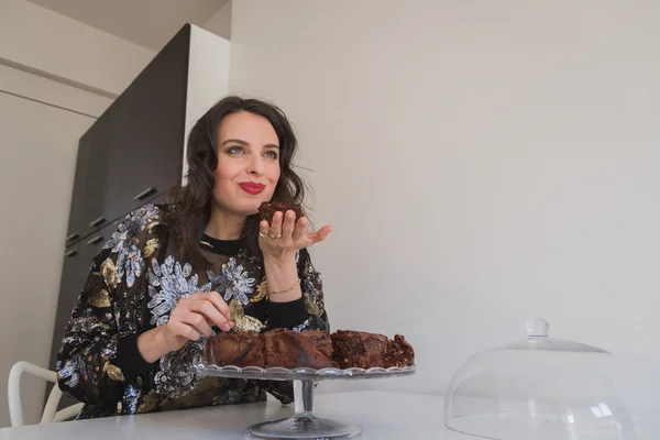 Beautiful young brunette posing with brownies — Stock Photo, Image