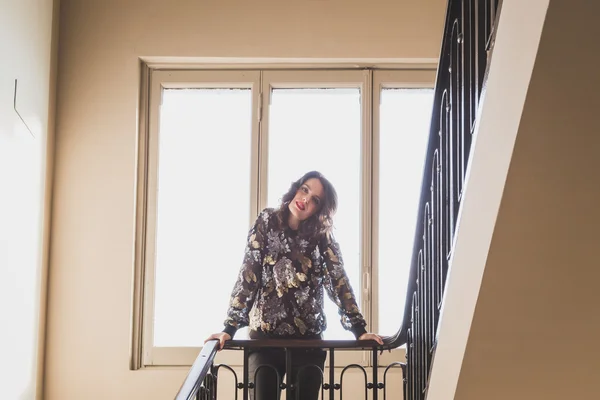 Retrato de uma bela jovem morena posando ao lado de uma janela — Fotografia de Stock