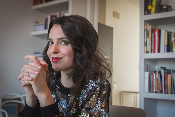 Portret van een mooie jonge brunette in de woonkamer — Stockfoto