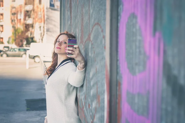 Vacker flicka med en selfie i en stadsmiljö — Stockfoto