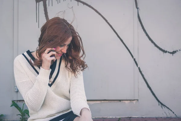 Hermosa chica hablando por teléfono en un contexto urbano — Foto de Stock