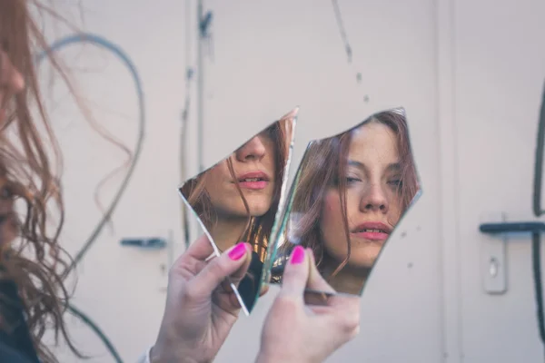 Schönes Mädchen, das sich selbst im Spiegel betrachtet — Stockfoto