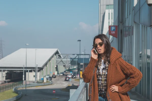 Menina bonita falando ao telefone em um contexto urbano — Fotografia de Stock