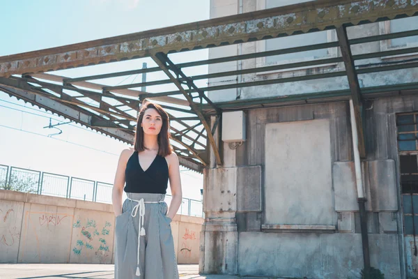 Beautiful brunette posing in an industrial context — Stock Photo, Image