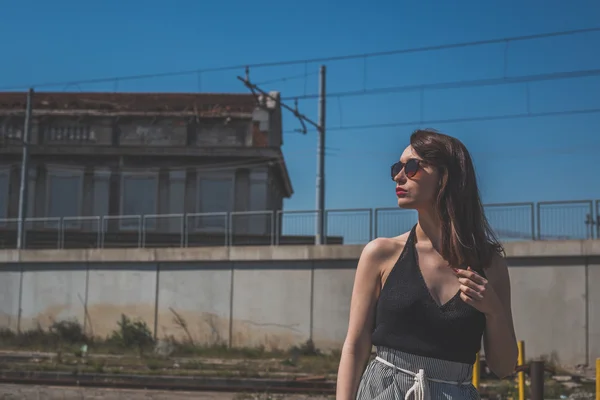 Hermosa morena posando en un contexto industrial —  Fotos de Stock