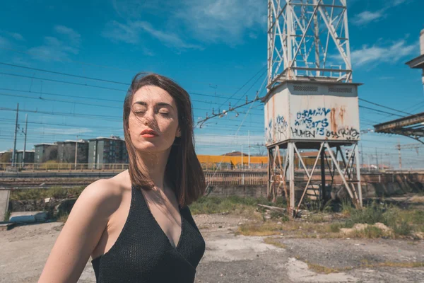 Beautiful brunette posing in an industrial context — Stock Photo, Image