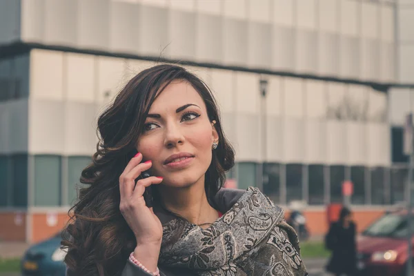 Güzel kız bir kentsel bağlamda telefonda konuşuyor — Stok fotoğraf