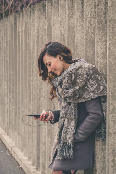 美丽的女孩，在城市街道上听音乐 — 图库照片