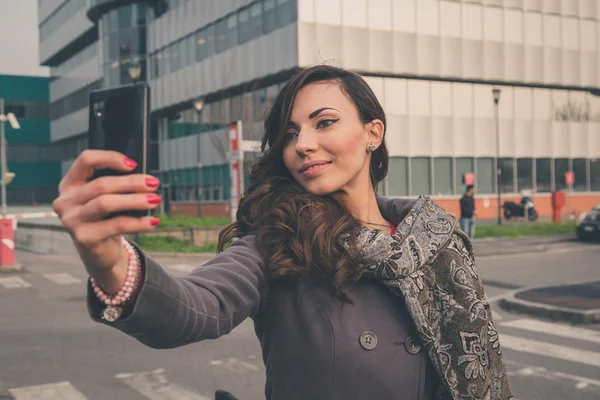 Krásná dívka s selfie v městském kontextu — Stock fotografie