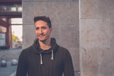 Genç adam bir kentsel bağlamda poz