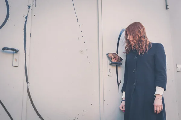 Beautiful girl looking at herself in a mirror — Stock Photo, Image