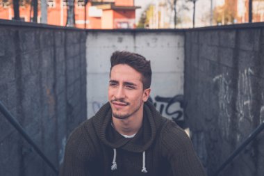 Genç adam bir kentsel bağlamda poz