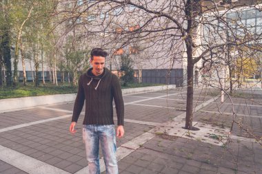 Genç adam bir kentsel bağlamda poz