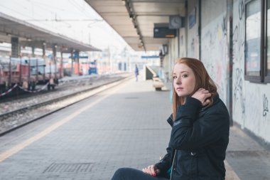 Güzel kız bir demiryolu istasyonunda poz