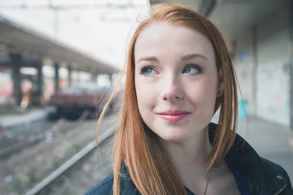 Krásná dívka pózuje v železniční stanici — Stock fotografie