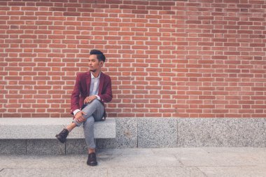 Şehir sokakta oturan yakışıklı Asya modeli