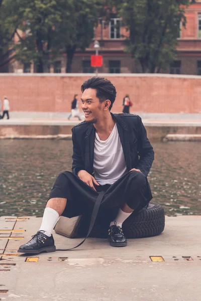 Handsome Asian model posing by an artificial basin — Stock Photo, Image