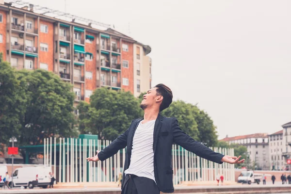 Handsome Asian model posing by an artificial basin — Stock Photo, Image