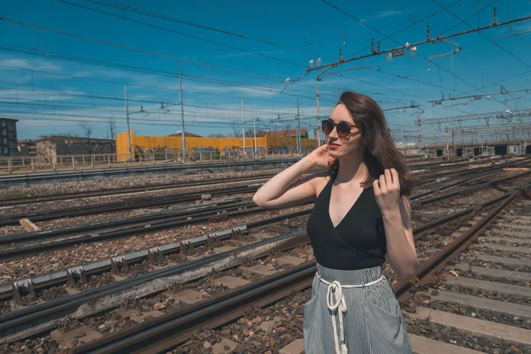 Vacker brunett poserar i ett industriellt sammanhang — Stockfoto