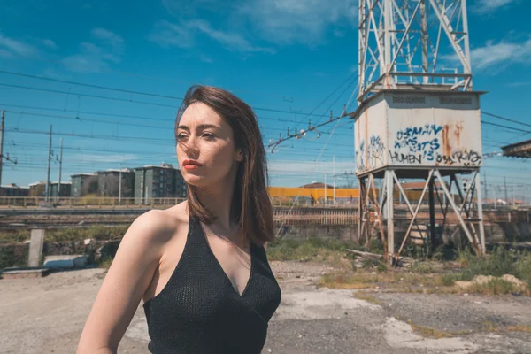 Hermosa morena posando en un contexto industrial —  Fotos de Stock