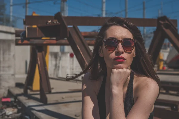 Linda morena posando em um contexto industrial — Fotografia de Stock