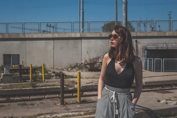 Beautiful brunette posing in an industrial context — Stock Photo, Image