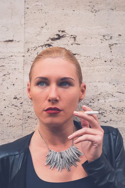 Beautiful girl smoking in the city streets — Stock Photo, Image