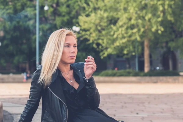 Beautiful girl smoking in the city streets — Stock Photo, Image