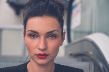 Güzel kız bir yürüyen merdiven üzerinde poz