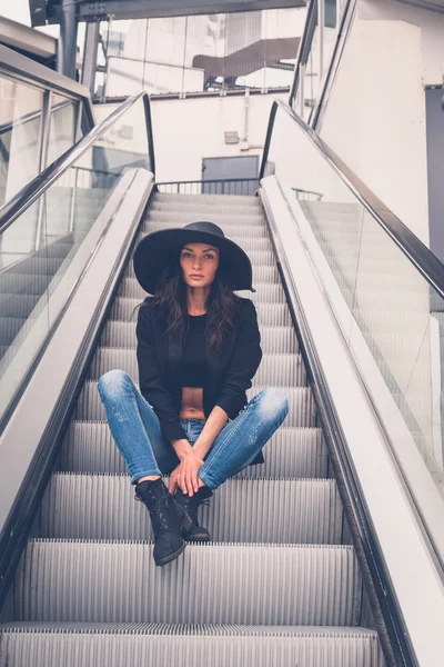 Schöne Mädchen posiert auf einer Rolltreppe — Stockfoto