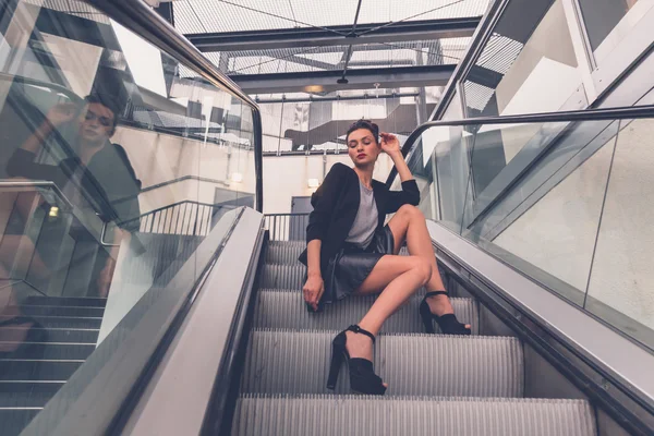 Beautiful girl posing on an escalator — Stock Photo, Image