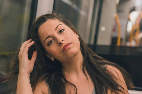 Beautiful curvy girl posing in a metro car — Stock Photo, Image