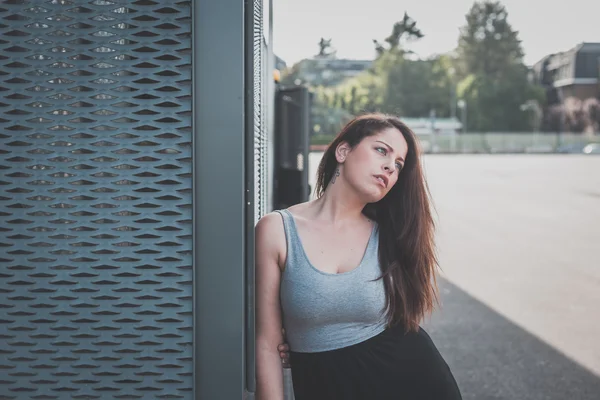 Mooi bochtige meisje poseren in een stedelijke context — Stockfoto